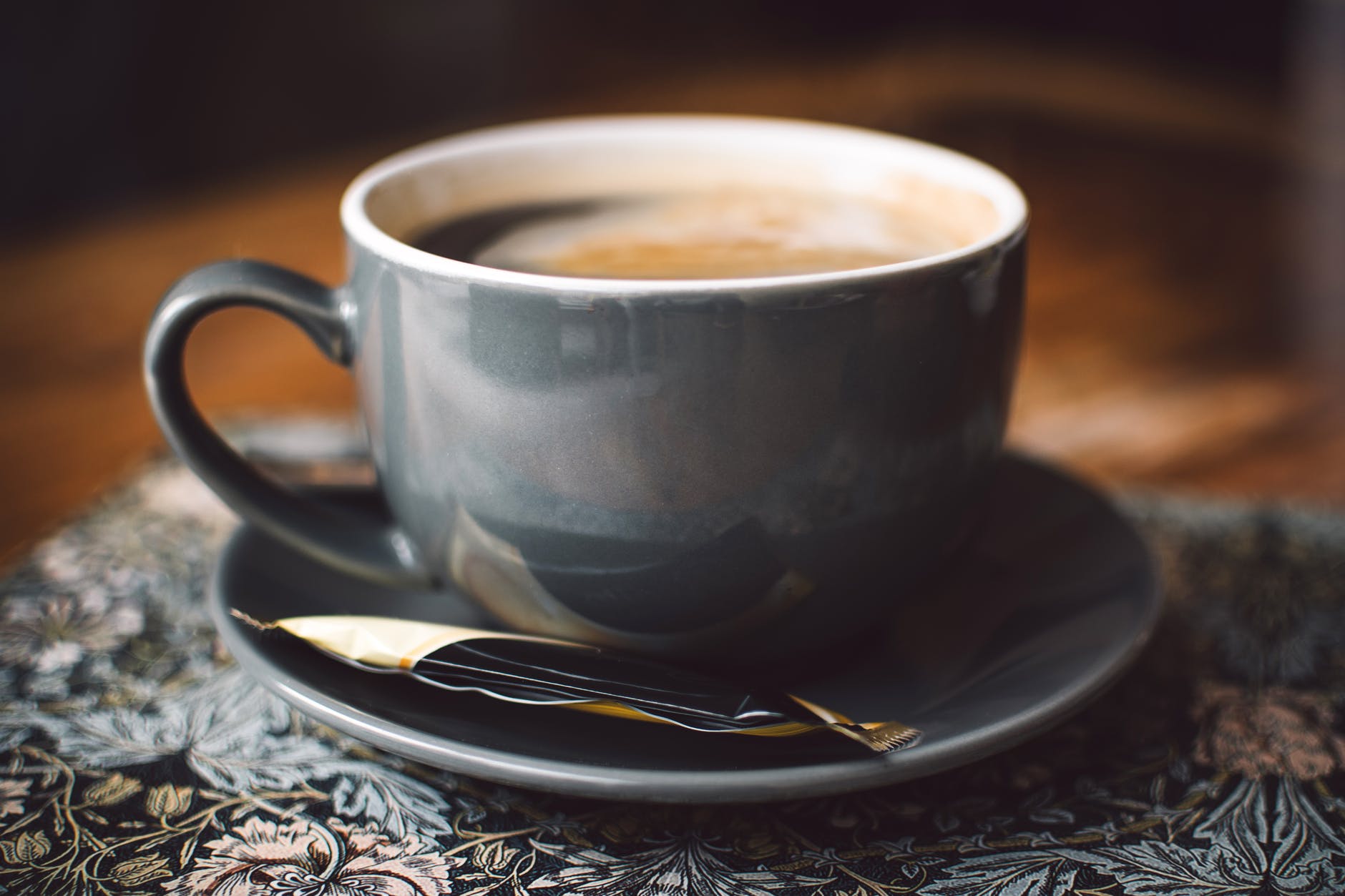 gray ceramic cup of coffee on round gray saucer